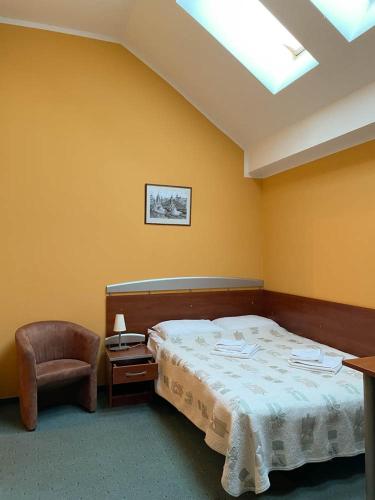a bedroom with a bed and a chair at Hotel SenS in Mierzyn