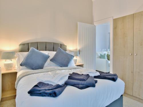 a bedroom with a large bed with blue pillows at Cur Cottage - Uk7809 in Coirantee