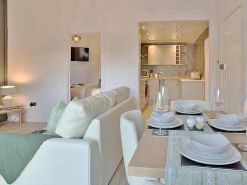 uma sala de estar com um sofá branco e uma mesa em Cur Cottage - Uk7809 em Coirantee