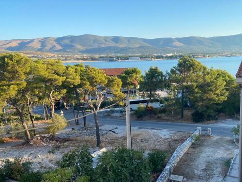 a view of a road and a lake with trees at Apartments Antonella in Trogir