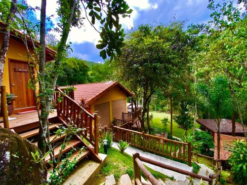 a house with a wooden staircase leading up to it at Espaço Viverde Penedo in Penedo