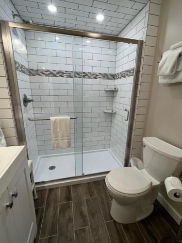 a bathroom with a toilet and a glass shower at Wiley Inn in Peru