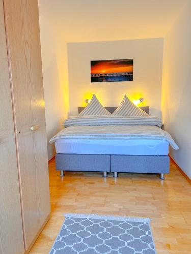 a bedroom with a large bed with a blue comforter at Haus Iderhoff- Wohnung 5 in Norderney