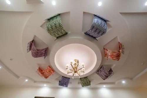 a room with a ceiling with colorful decorations at Caravan Hotel in Khiva