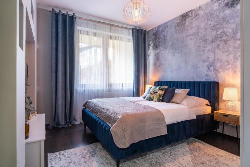 sypialnia z dużym łóżkiem z niebieskim zagłówkiem w obiekcie ApartamentySnu, Słoneczny Standard z parkingiem, Centrum w Radomiu