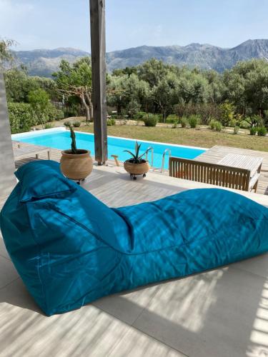 a blue bean bag bed on a patio with a pool at Villa Mouria private villa just 200m from the sea in Pogoniá