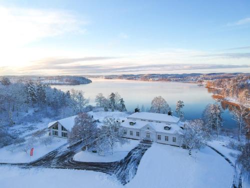 an aerial view of a house in the snow at Liljeholmen Herrgård Hostel in Rimforsa
