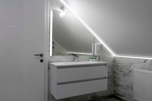 a bathroom with a sink and a mirror at Hiška pod gradom in Celje