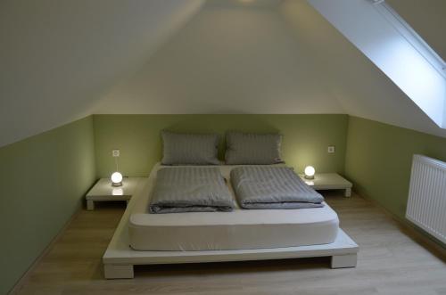 een slaapkamer met een bed met 2 nachtkastjes bij Hiška pod gradom in Celje