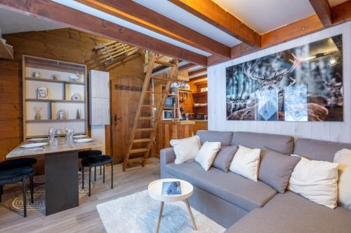 uma sala de estar com um sofá e uma mesa em Le Mazot - mezzanine with nice view em Chamonix-Mont-Blanc