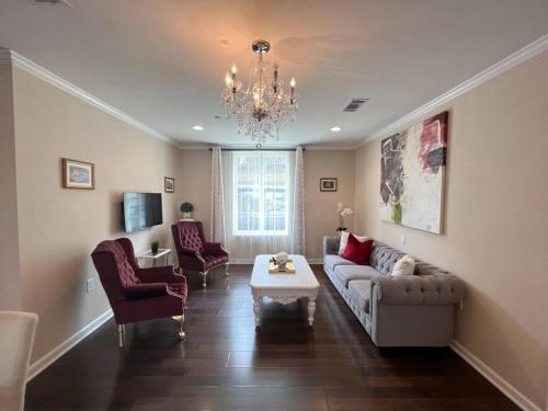 a living room with a couch and chairs and a chandelier at Tise Plaza Condos in New Orleans