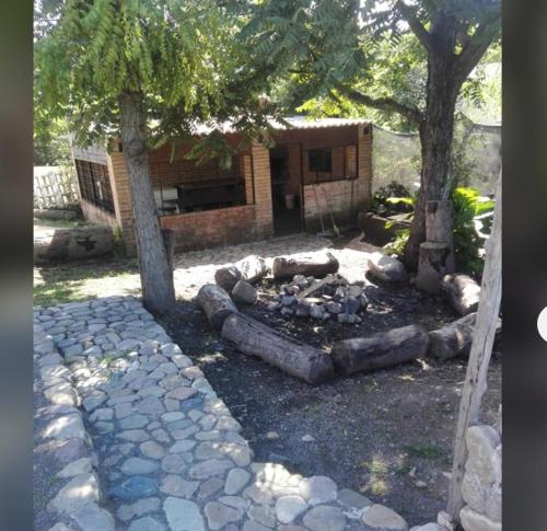 einen Hinterhof mit einer Feuerstelle und zwei Bäumen in der Unterkunft Los Crespones, Vaqueros in Vaqueros