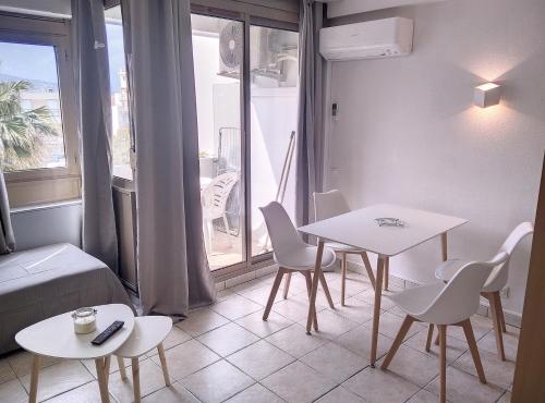 un salon avec une table et des chaises et une fenêtre dans l'établissement Résidence Graziella Studio 502, à Juan-les-Pins