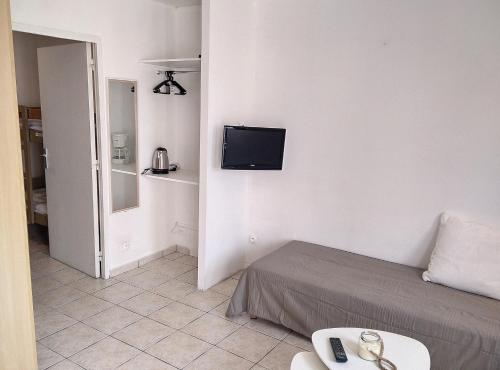 Habitación con cama y TV en la pared. en Résidence Graziella Studio 502, en Juan-les-Pins