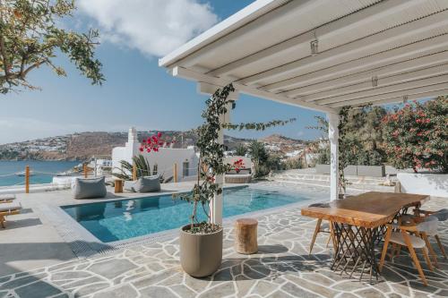 a patio with a table and a swimming pool at myMykonos Villa I in Platis Gialos