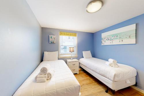 two beds in a room with blue walls at Town of Rehoboth Beach 24 Rehoboth Ave in Rehoboth Beach