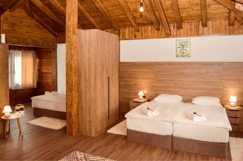 a bedroom with two beds and a wooden wall at Varo&scaron; Čar&scaron;ija in Trebinje