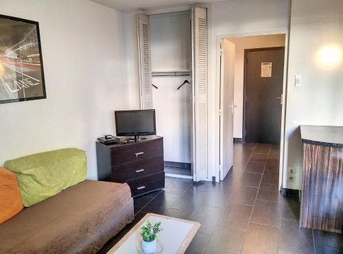 un salon avec un canapé et une télévision dans l'établissement Résidence Graziella Studio 110, à Juan-les-Pins