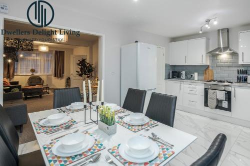 a kitchen and dining room with a table and chairs at Dwellers Delight Living Ltd Serviced Accommodation Fabulous House 3 Bedroom, Hainault Prime Location ,Greater London with Parking & Wifi, 2 bathroom, Garden in Chigwell
