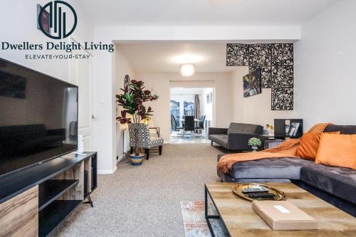 a living room with a couch and a tv at Dwellers Delight Living Ltd Serviced Accommodation Fabulous House 3 Bedroom, Hainault Prime Location ,Greater London with Parking & Wifi, 2 bathroom, Garden in Chigwell