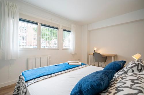 Un dormitorio con una cama grande con almohadas azules. en For You Rentals Cozy Apartment La Vaguada Madrid PMO10 en Madrid