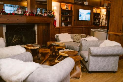 a living room with couches and tables and a fireplace at Green Life Bansko in Bansko
