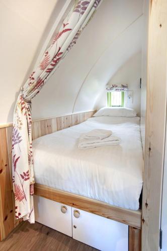 a bedroom with a white bed in an attic at Finest Retreats - Humbleton Glamping in Hexham