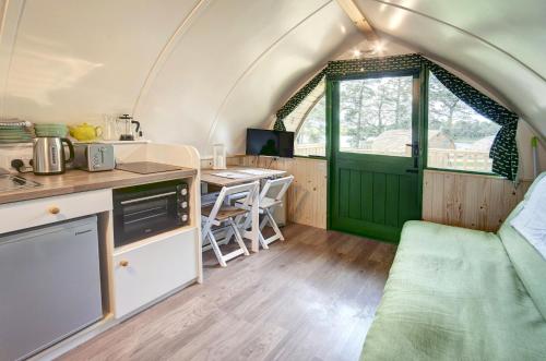 Finest Retreats - Barebones Glamping في هيكسهام: مطبخ وغرفة طعام في منزل صغير
