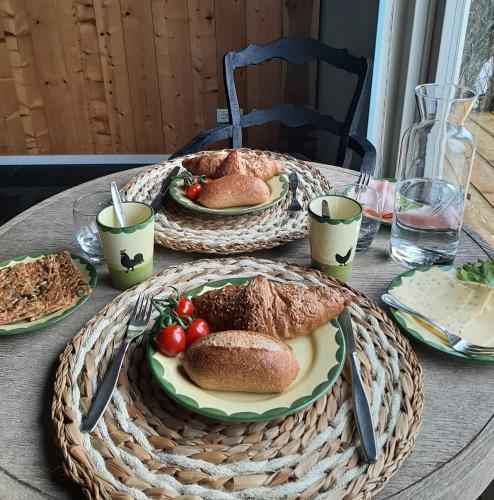 a table with two plates of bread and tomatoes on it at B&B De Verre Kijker in Barsingerhorn