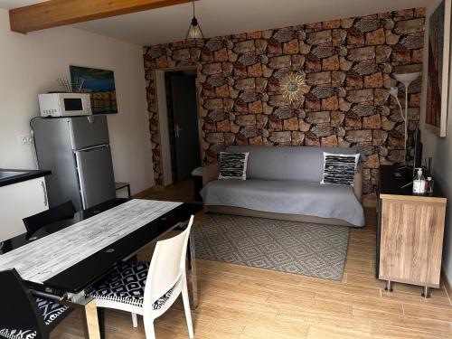 - un salon avec un canapé et un mur en pierre dans l'établissement Studio indépendant Lisieux, à Lisieux