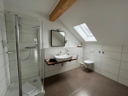 ein Bad mit einem Waschbecken, einer Dusche und einem WC in der Unterkunft Wurznwirt in Schneizlreuth