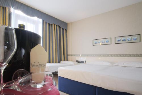 a hotel room with a bed and a glass of wine at Hotel Viest in Vicenza