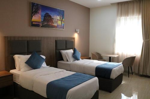 Cette chambre comprend 2 lits et une fenêtre. dans l'établissement فندق منار بارك, à Riyad