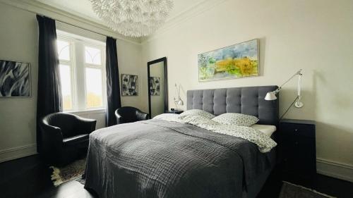 1 dormitorio con 1 cama, 2 sillas y lámpara de araña en ApartmentInCopenhagen Apartment 1526, en Copenhague