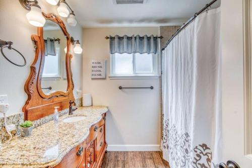 ein Bad mit einem Waschbecken und einem Spiegel in der Unterkunft X-Large Spacious Deluxe House Fastest Wi-Fi in Fresno