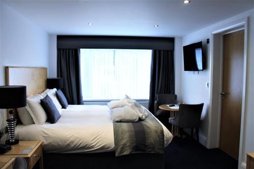 a hotel room with a bed and a window at Belgrave Sands Hotel & Spa in Torquay