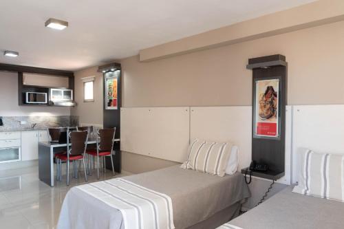 1 dormitorio pequeño con 1 cama y cocina en Sol de Piedra Apart, Suites & Spa en Córdoba