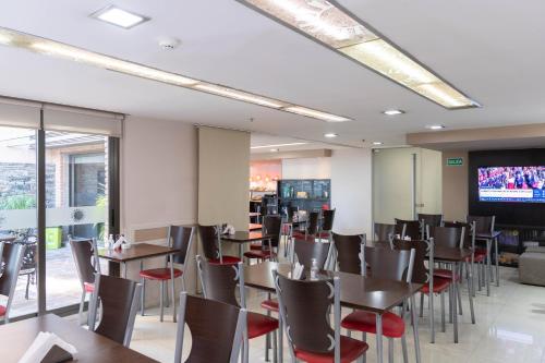 a restaurant with tables and chairs and a flat screen tv at Sol de Piedra Apart, Suites & Spa in Cordoba