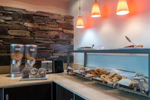 a kitchen with a counter with a bunch of pastries at Sol de Piedra Apart, Suites & Spa in Cordoba