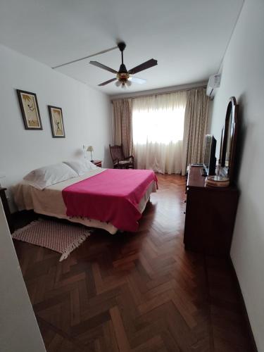 1 dormitorio con 1 cama y ventilador de techo en DEPARTAMENTO EN MICROCENTRO CON COCHERA en Salta