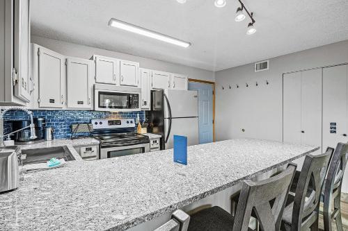 a kitchen with white cabinets and a table with chairs at Full Moon Condo in Lake Ozark