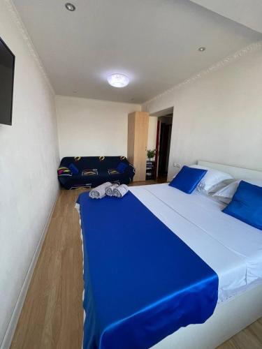 シムケントにあるДомашний уютのベッドルーム(青い大型ベッド、青いシーツ付)