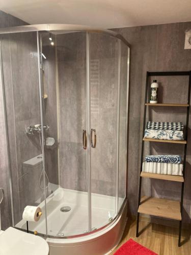 a shower with a glass door in a bathroom at Pokoje Gościnne Nowy Świat in Supraśl