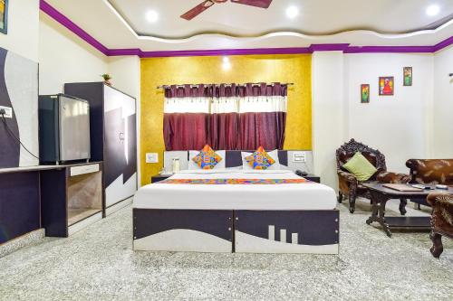FabExpress Relax Inn I, Udaipur في أودايبور: غرفة نوم بسرير وتلفزيون بشاشة مسطحة