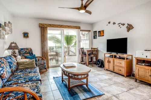 a living room with a couch and a tv at Kona Riviera Villa #104 in Kailua-Kona