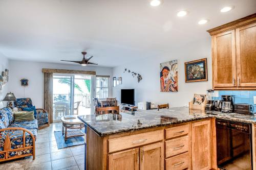 a kitchen with a counter top and a living room at Kona Riviera Villa #104 in Kailua-Kona