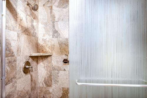 a shower with a white door in a bathroom at Kona Riviera Villa #104 in Kailua-Kona