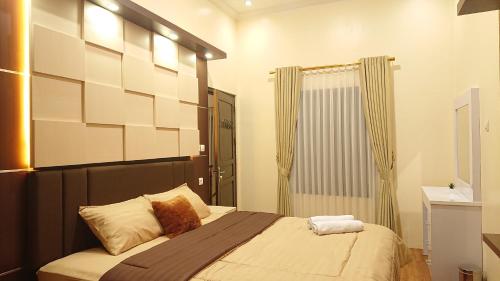 a bedroom with a bed with a mirror and a shower at Sapphire Village Guesthouse in Rempawah