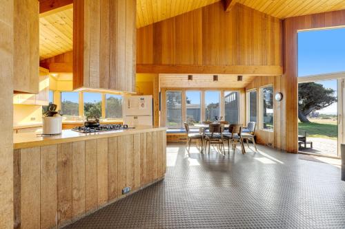 a kitchen with wooden cabinets and a table with chairs at Samson Getaway in Sea Ranch