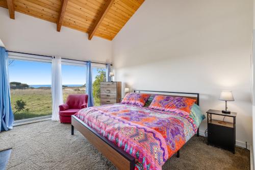 a bedroom with a bed and a chair and a window at Samson Getaway in Sea Ranch
